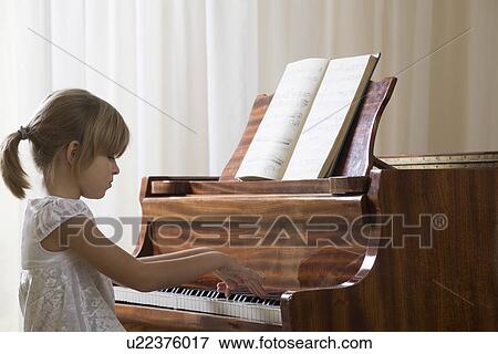 Girl (5-6) playing piano View Large Photo Image Stock Photo - Girl (5-6) playing piano. Fotosearch