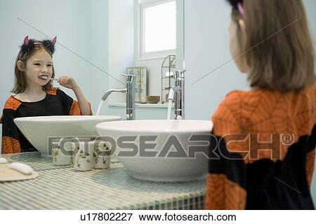 Girl brushing teeth in bathroom View Large Photo Image Stock Photo - Girl brushing teeth in bathroom. Fotosearch