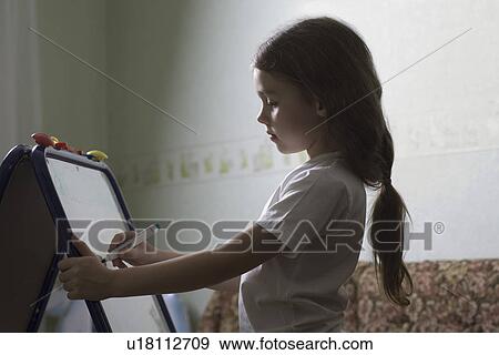 Girl drawing on plastic board in home View Large Photo Image Stock Photo - Girl drawing on plastic board in home. Fotosearch