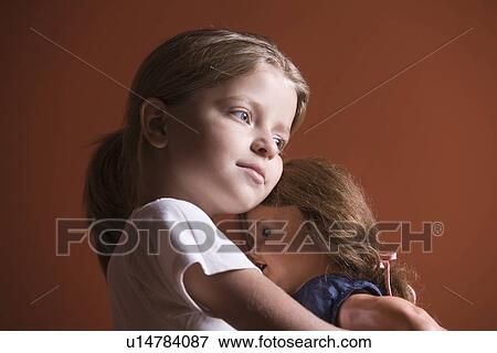 Girl embracing doll View Large Photo Image Stock Photo - Girl embracing doll. Fotosearch