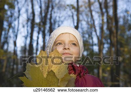 Girl holding leaves in park View Large Photo Image Stock Image - Girl holding leaves in park. Fotosearch