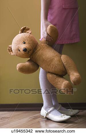 Girl holding teddy bear in home View Large Photo Image Stock Image - Girl holding teddy bear in home. Fotosearch