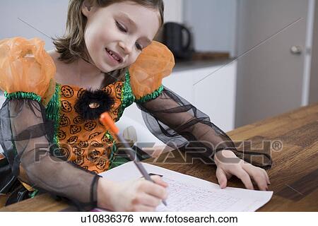 Stock Photograph - Girl in costume drawing at table. Fotosearch