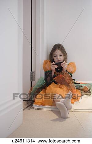 Picture - Girl in costume sitting on floor. Fotosearch