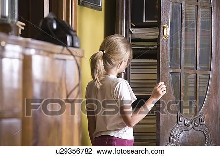Girl opening cupboard door View Large Photo Image Stock Image - Girl opening cupboard door. Fotosearch