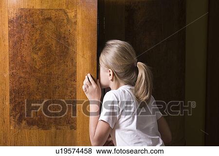 Stock Photo - Girl opening wardrobe door. Fotosearch