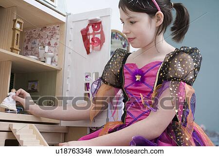 Stock Photo - Girl playing with doll house. Fotosearch