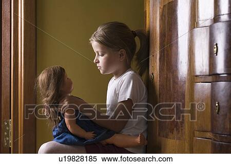 Stock Photography - Girl playing with doll in home. Fotosearch