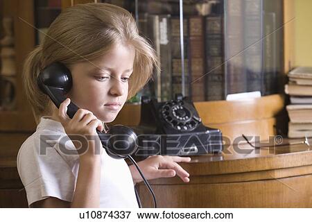 Stock Photo - Girl using telephone at home. Fotosearch