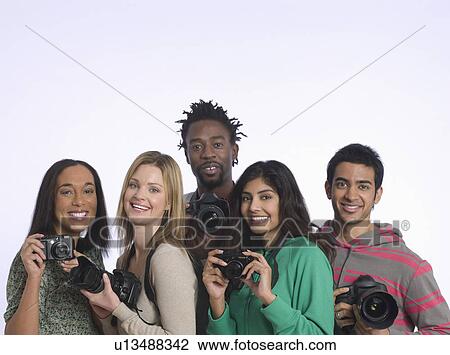Group of young people holding cameras studio shot View Large Photo Image Stock Image - Group of young people holding cameras studio shot. Fotosearch