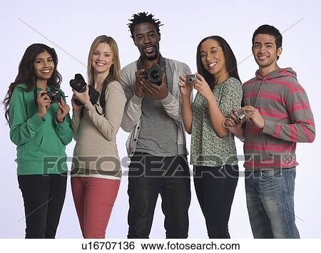 Stock Photograph - Group of young people holding cameras studio shot. Fotosearch
