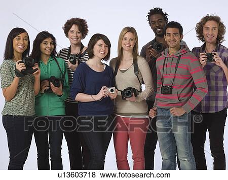 Stock Photo - Group portrait of young people holding cameras studio shot. Fotosearch