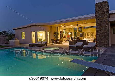 House exterior with sunloungers on patio by swimming pool View Large Photo Image Picture - House exterior with sunloungers on patio by swimming pool. Fotosearch
