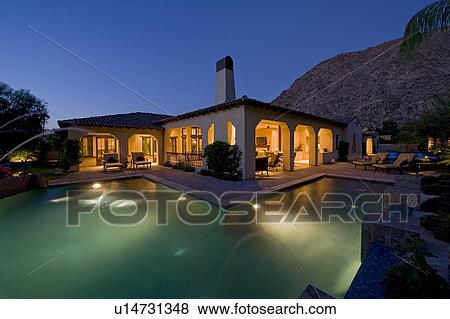 House exterior with swimming pool in backyard at dusk View Large Photo Image Stock Photo - House exterior with swimming pool in backyard at dusk. Fotosearch