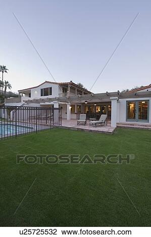Stock Image - Lawn and swimming pool of Palm Springs home exterior. Fotosearch