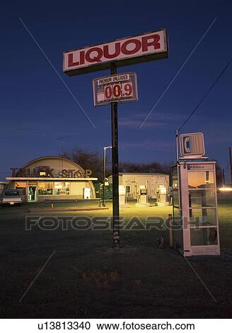 Stock Image - Liquor sign beside phone box at truck stop. Fotosearch