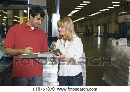 Stock Image - Man and woman working in newspaper factory. Fotosearch