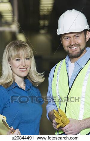 Stock Image - Man and woman working in newspaper factory. Fotosearch