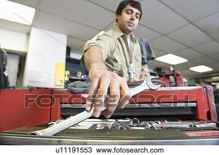 Stock Image - Man in workshop with tools. Fotosearch