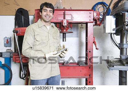 Stock Image - Man in workshop with tools. Fotosearch