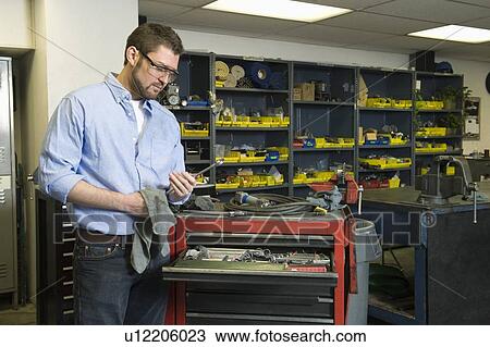 Stock Image - Man in workshop with toolsMan in workshop with tools. Fotosearch