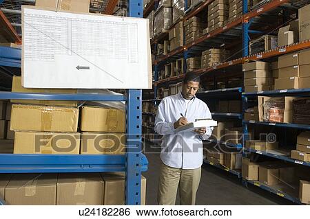 Man inspecting boxes in distribution warehouse View Large Photo Image Stock Photograph - Man inspecting boxes in distribution warehouse. Fotosearch