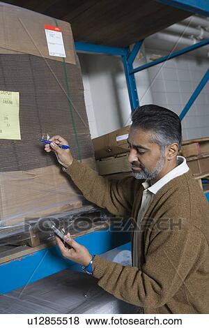 Man making inventory in factory View Large Photo Image Stock Photo - Man making inventory in factory. Fotosearch