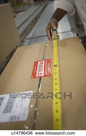 Man measuring cardboard box close-up View Large Photo Image Stock Photograph - Man measuring cardboard box close-up. Fotosearch