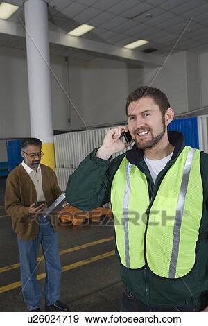 Man standing in factory using telephone View Large Photo Image Stock Photo - Man standing in factory using telephone. Fotosearch