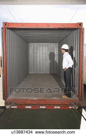 Man standing inside empty container View Large Photo Image Picture - Man standing inside empty container. Fotosearch