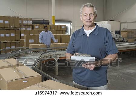 Man working in distribution warehouse View Large Photo Image Stock Photo - Man working in distribution warehouse. Fotosearch