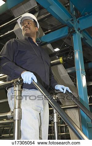 Picture - Man working in newspaper factory low angle. Fotosearch