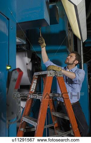 Stock Photo - Man working in newspaper factory. Fotosearch