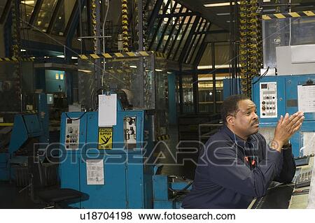 Stock Photo - Man working in newspaper factory. Fotosearch