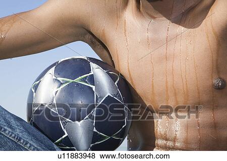 Mans torso with soccer ball View Large Photo Image Stock Photo - Mans torso with soccer ball. Fotosearch