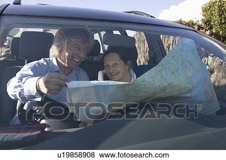 Stock Photo - Mature couple laugh over a map. Fotosearch