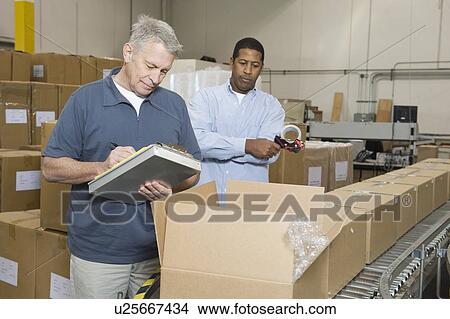 Picture - Men inspecting goods in distribution warehouse. Fotosearch