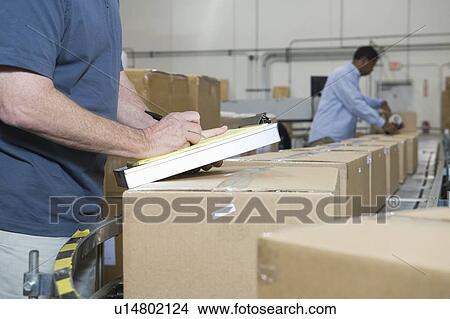 Picture - Men working in distribution warehouse close-up. Fotosearch