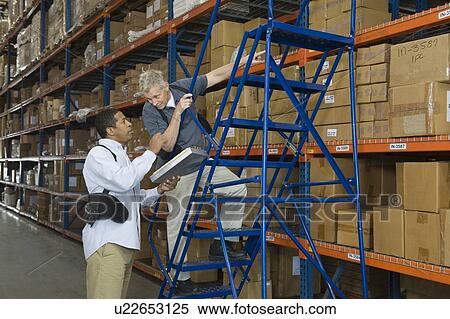 Stock Photography - Men working in distribution warehouse. Fotosearch