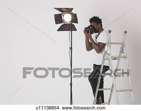 Picture - Mid adult (30-35 years) photographer in studio. Fotosearch