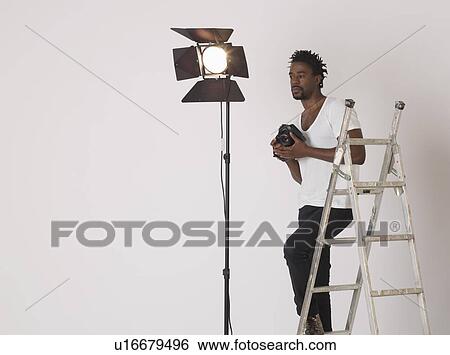 Mid adult (30-35 years) photographer in studio View Large Photo Image Stock Photograph - Mid adult (30-35 years) photographer in studio. Fotosearch