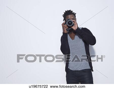 Stock Image - Mid adult (30-35 years) photographer making photo studio shot. Fotosearch