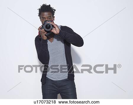 Stock Photo - Mid adult (30-35 years) photographer making photo studio shot. Fotosearch