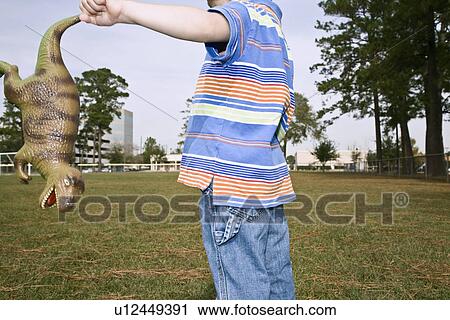 Mid section of boy with toy dinosaur View Large Photo Image Stock Image - Mid section of boy with toy dinosaur. Fotosearch