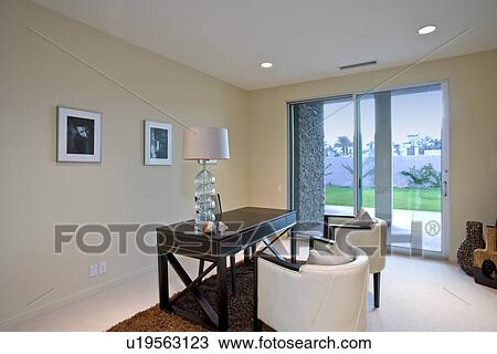 Stock Image - Modern house interior with desk and chairs. Fotosearch