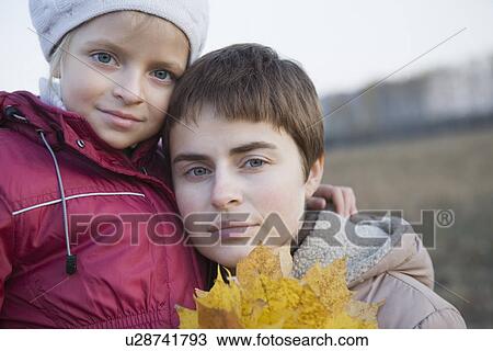 Mother and daughter holding leaves in field portrait View Large Photo Image Stock Image - Mother and daughter holding leaves in field portrait. Fotosearch