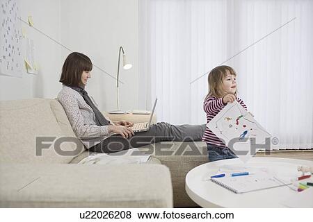 Stock Photo - Mother and daughter in living room. Fotosearch