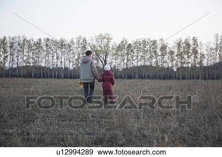 Mother and daughter walking in field View Large Photo Image Stock Photo - Mother and daughter walking in field. Fotosearch