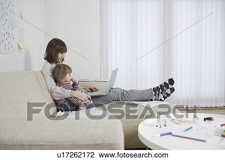 Mother and daughter with laptop in living room View Large Photo Image Stock Image - Mother and daughter with laptop in living room. Fotosearch