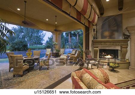 Stock Image - Open plan Palm Springs sitting room with lit fire. Fotosearch